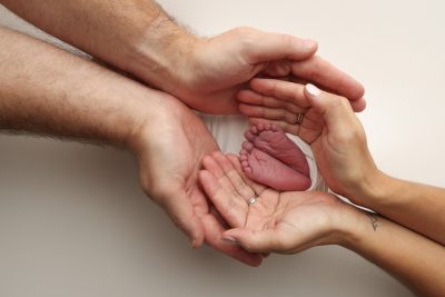 a-father-and-mother-hold-the-feet-of-a-newborn-chi-2024-10-07-23-13-43-utc